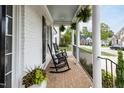 Inviting covered porch with rocking chairs, potted plants, and brick flooring, perfect for relaxing outdoors at 10709 Thornbury Crest Ct, Raleigh, NC 27614