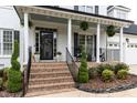 Charming front porch with brick steps, columns, and decorative plants offering a welcoming entrance at 10709 Thornbury Crest Ct, Raleigh, NC 27614