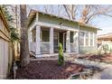 Charming green home with a front porch nestled among mature trees at 1105 W Lenoir St, Raleigh, NC 27603