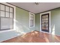Cozy covered front porch with black door, wood floors, and lots of natural light at 1105 W Lenoir St, Raleigh, NC 27603