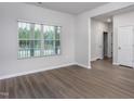 Bright living room featuring a large window and stylish wood-look flooring at 11430 International Dr, Middlesex, NC 27557