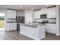Modern kitchen featuring white cabinets, stainless steel appliances, and an island with granite countertops at 11682 International Dr, Middlesex, NC 27557