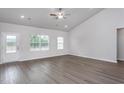 Bright living room with vaulted ceilings, laminate wood flooring, and natural light from multiple windows at 11740 International Dr, Middlesex, NC 27557