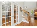 Inviting foyer featuring hardwood floors, staircase with wood railings, and elegant french doors at 1503 Anterra Dr, Wake Forest, NC 27587