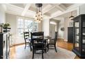 Formal dining room featuring hardwood floors, coffered ceilings, and elegant light fixture at 1545 Heritage Links Dr, Wake Forest, NC 27587