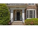 The front entrance of a stone home with stately pillars and manicured landscaping at 1545 Heritage Links Dr, Wake Forest, NC 27587