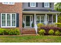A close-up of the home's entrance, featuring a cozy front porch and manicured landscaping at 1809 Green Ford Ln, Apex, NC 27502