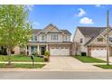 Two-story home with vinyl siding and brick accents, two-car garage, and small front lawn at 1919 Sinclair Trce, Burlington, NC 27215