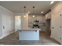 Open concept kitchen featuring island with granite countertop, and stainless steel appliances at 250 Bluejay St, Clayton, NC 27520
