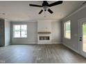 Spacious living room features a decorative fireplace, large windows, and new flooring at 250 Bluejay St, Clayton, NC 27520