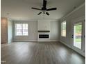 Open living room with fireplace, ceiling fan, and luxury vinyl plank flooring at 250 Bluejay St, Clayton, NC 27520