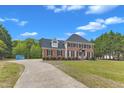 Classic two-story brick home with a long driveway and a well-maintained lawn at 2804 Brenfield Dr, Raleigh, NC 27606