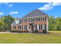 Attractive two-story brick home featuring a well-kept front lawn and black shutters at 2804 Brenfield Dr, Raleigh, NC 27606