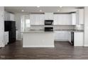 Open kitchen features white cabinets, granite countertops, black appliances, and a central island at 302 Shiloh Way, Mebane, NC 27302