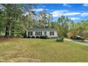 Quaint home features lush green lawn with lots of mature trees surrounding the house at 308 Plaza Dr, Garner, NC 27529