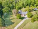 Aerial view of a home nestled among trees with a long driveway and surrounding greenery and a small outbuilding at 317 William Dr, Benson, NC 27504