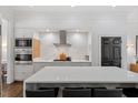 Modern kitchen featuring a large island, stainless steel appliances, and sleek white cabinetry at 3920 Bentley Brook Dr, Raleigh, NC 27612