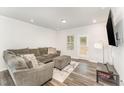 Comfortable living room featuring a plush gray sectional, ottoman, and an exterior door at 4005 Sierra Pelona Dr, Raleigh, NC 27616