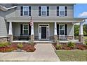 Charming front porch with black door, comfortable seating, and well manicured landscaping at 46 Twelve Oaks Dr, Willow Springs, NC 27592