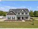 Charming two-story home with a welcoming front porch, landscaped yard, and stone accents at 46 Twelve Oaks Dr, Willow Springs, NC 27592