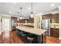 Spacious kitchen island with granite countertops, seating, and stainless steel appliances for modern living and entertaining at 521 Wildwood Farm Way, Holly Springs, NC 27540
