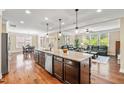 Open-concept kitchen featuring a large island with granite countertops and seating for entertaining guests at 521 Wildwood Farm Way, Holly Springs, NC 27540