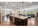 Spacious open-concept kitchen with an island, stainless steel appliances, and an eat-in kitchen area adjacent to the living room at 521 Wildwood Farm Way, Holly Springs, NC 27540