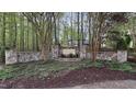 Stone entrance to the Walker Woods community, surrounded by towering trees at 572 W Walker Woods Ln, Clayton, NC 27527