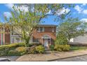 Inviting townhouse with a brick facade, mature trees, and a well-maintained front yard at 5900 Shady Grove Cir, Raleigh, NC 27609