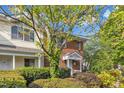 Brick and siding townhouse with a manicured front yard and mature tree providing shade at 5900 Shady Grove Cir, Raleigh, NC 27609