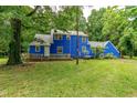 Backyard view of blue home showcasing an expansive wooden deck at 6238 Old 421 Rd, Liberty, NC 27298