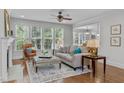 Inviting living room with hardwood floors, a cozy fireplace, large windows, and comfortable seating at 629 Peach Orchard Pl, Cary, NC 27519