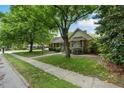 Beautiful one-story brick home with mature trees, green lawn and established landscaping at 704 W Front St, Burlington, NC 27215