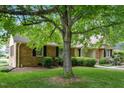 Quaint brick home with lush landscaping, mature trees, and welcoming front entrance at 704 W Front St, Burlington, NC 27215