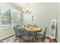 Cozy dining area with natural light from the large window and decorative light fixture at 7328 Caversham Way, Raleigh, NC 27617
