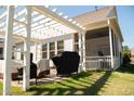 Backyard featuring a covered patio with a pergola, offering a perfect space for outdoor dining and relaxation at 828 Traditions Ridge Dr, Wake Forest, NC 27587