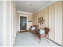 Welcoming covered porch features cozy seating with wicker chairs, pillows, and a decorative metal tree sculpture at 833 Gaston Manor Dr, Durham, NC 27703