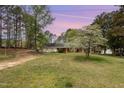 Charming home featuring a lush, vibrant front yard under a soft, colorful twilight sky at 903 Creech Rd, Garner, NC 27529