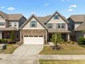 Two-story home with stone facade, attached garage, and well-maintained lawn at 1033 Laredo Ln, Durham, NC 27703