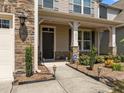 Inviting front porch with classic columns, stone accents, and a well-manicured garden at 1033 Laredo Ln, Durham, NC 27703
