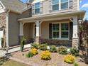 Inviting porch featuring white columns with stone accents and colorful, well-maintained landscaping at 1033 Laredo Ln, Durham, NC 27703