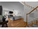 Bright living room with hardwood floors, fireplace, large windows, and an open floor plan with modern decor and a staircase at 107 Deer St, Carrboro, NC 27510