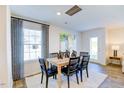 Bright dining area featuring modern light fixtures, a wooden table, and elegant curtains at 108 Red Maple St, Sanford, NC 27332
