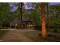 Long driveway leading to a stately brick home, nestled among mature trees and professional landscaping at 10805 The Olde Pl, Raleigh, NC 27614