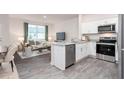 Open-concept kitchen featuring white cabinetry, stainless steel appliances, granite countertops and sight lines to the living room at 110 Red Maple St, Sanford, NC 27332
