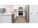 Modern kitchen with stainless steel appliances, white cabinets, and granite counters at 110 Red Maple St, Sanford, NC 27332