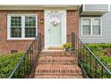 Inviting front entrance with brick steps, black railing, and a white front door with decorative wreath at 120 Barbary Ct, Cary, NC 27511