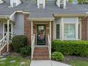 Close-up of the front entry featuring brick steps, a covered porch, and lush greenery at 1234 Shadowbark Ct, Raleigh, NC 27603