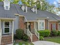 View of townhome featuring brick facade, dormer windows, and a walkway leading to the front door at 1234 Shadowbark Ct, Raleigh, NC 27603