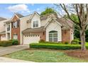Inviting two-story home with a well-kept lawn and a combination brick and beige exterior at 13338 Ashford Park Dr, Raleigh, NC 27613